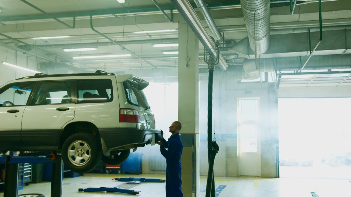 In-ground scissor lift raising a grey sedan